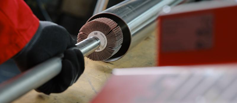 Bild på person som slipar rör invändigt med lamellslipstift